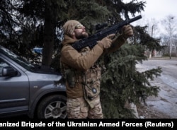 A Ukrainian soldier watches for Russian drones during the evacuation of a wounded soldier from Druzhkivka on February 27.