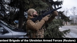 A Ukrainian soldier monitoring the sky for Russian drones during an evacuation of an injured service member.