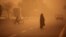 People cross a street as a heavy sandstorm hits the Iranian city of Ahvaz.