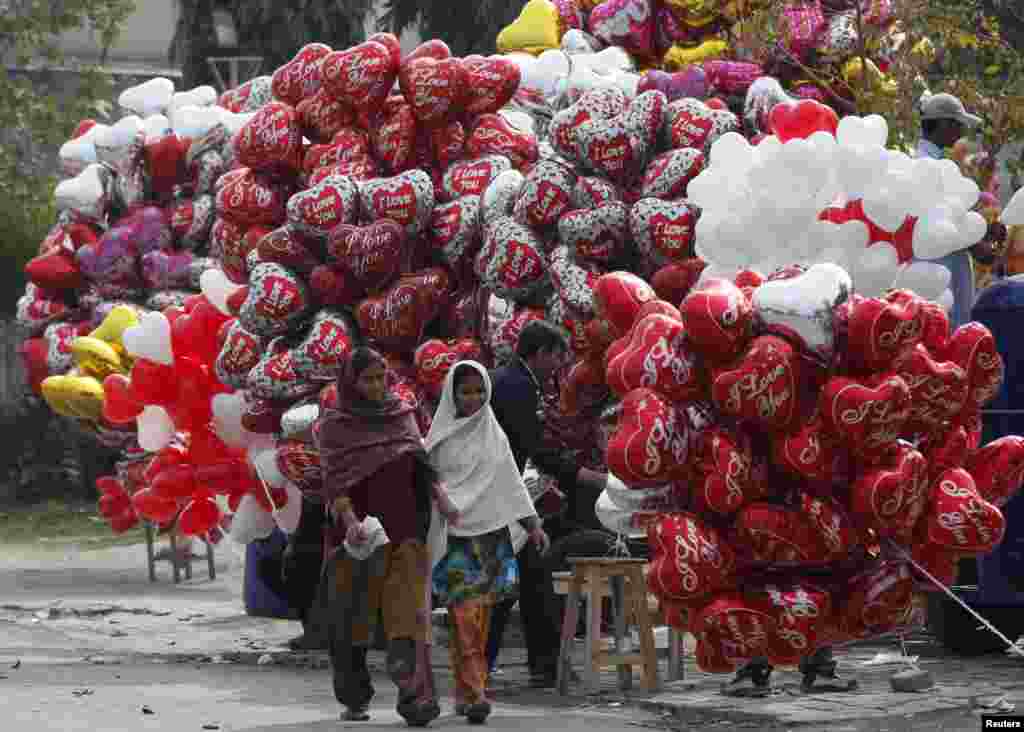 Women walk past heart-shaped balloons on Valentine's Day in Lahore, Pakistan. (Reuters/Mohsin Raza)