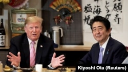 U.S. President Donald Trump talks with Japanese Prime Minister Shinzo Abe during a couples dinner with first lady Melania Trump and Abe's wife Akie in Tokyo, May 26, 2019