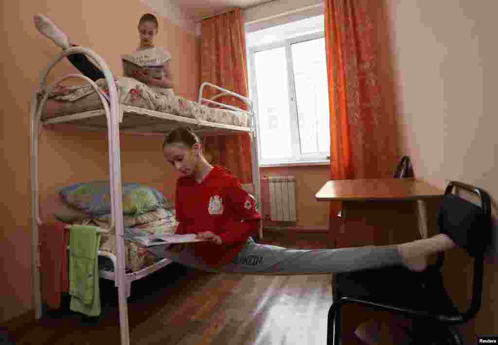 Anastasia Shevtsova (right) and Yulia Lyakhovykh do leg-splits as they study for an exam and a performance by the graduates of the State Theatre of Opera and Ballet at the college&#39;s campus in the Siberian city of Krasnoyarsk, Russia. (Reuters/ Ilya Naymushin)