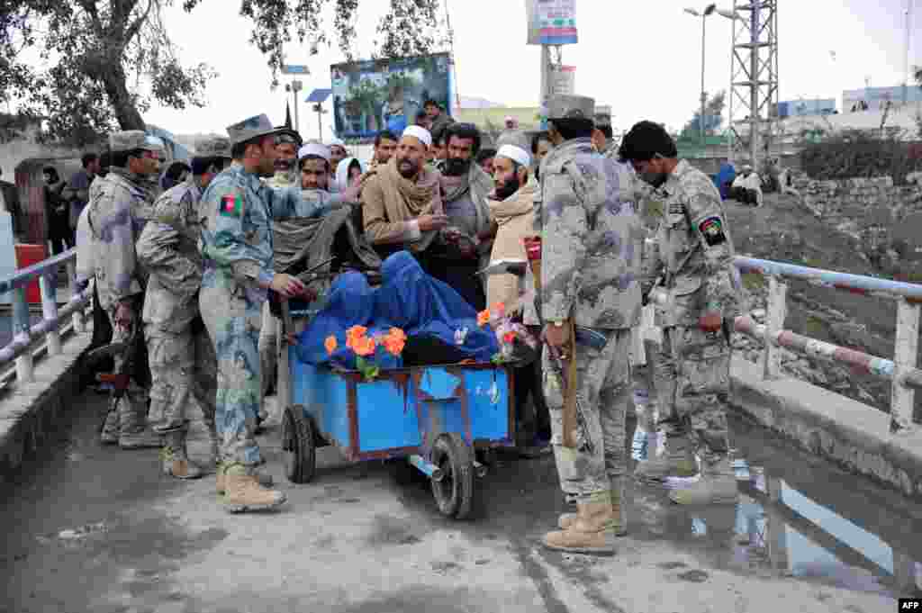 Afghan residents speak with border guards as they wait at the main border crossing at Torkham, between Afghanistan and Pakistan. Torkham was closed by Pakistani authorities. Hundreds of Afghans, including, women, children, the elderly, and people who were going from Afghanistan to Pakistan for treatment have been waiting for the border to open for several days. (AFP/Noorullah Shirzada)