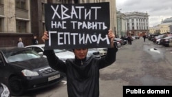 Гражданский активист Ринат Кибраев стоит с плакатом у здания Государственной думы России. Москва, 30 сентября 2013 года.