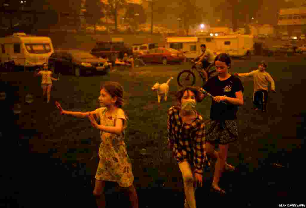 Children play at the showgrounds in the southern New South Wales town of Bega where they are camping after being evacuated from nearby sites affected by bushfires on December 31, 2019. Thousands of holidaymakers and locals were forced to flee to beaches in fire-ravaged southeast Australia on December 31, as blazes ripped through popular tourist areas leaving no escape by land.&nbsp; Contemporary Issues: Second Prize, Singles - Sean Davey,&nbsp;​Agence France-Presse