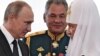 Russian President Vladimir Putin (left), Russian Patriarch Kirill of Moscow (right), and Russian Defense Minister Sergei Shoigu talk while visiting a marine church in St. Petersburg. (file photo)