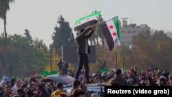 Syrians celebrate the regime change in Aleppo on December 8.