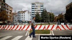 Një qytetar duke kaluar pranë barrierës që ndanë Mitrovicën jugore dhe veriore