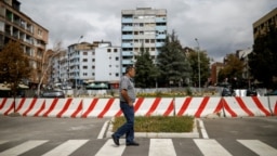Një qytetar duke kaluar pranë barrierës që ndanë Mitrovicën jugore dhe veriore