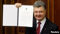Президент Петро Порошенко демонструє підписаний закон про ратифікацію Угоди про асоціацію з Євросоюзом