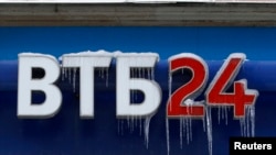 Russia -- A sign displaying the logo of VTB Bank, covered with icicles, is seen above the bank office in central Moscow, February 27, 2012