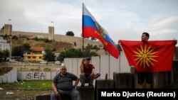 Supporters of opposition party VMRO-DPMNE hold Russian and Macedonian flags as they take part in a protest over the compromise solution in Macedonia's dispute with Greece over the country's name in Skopje last month.