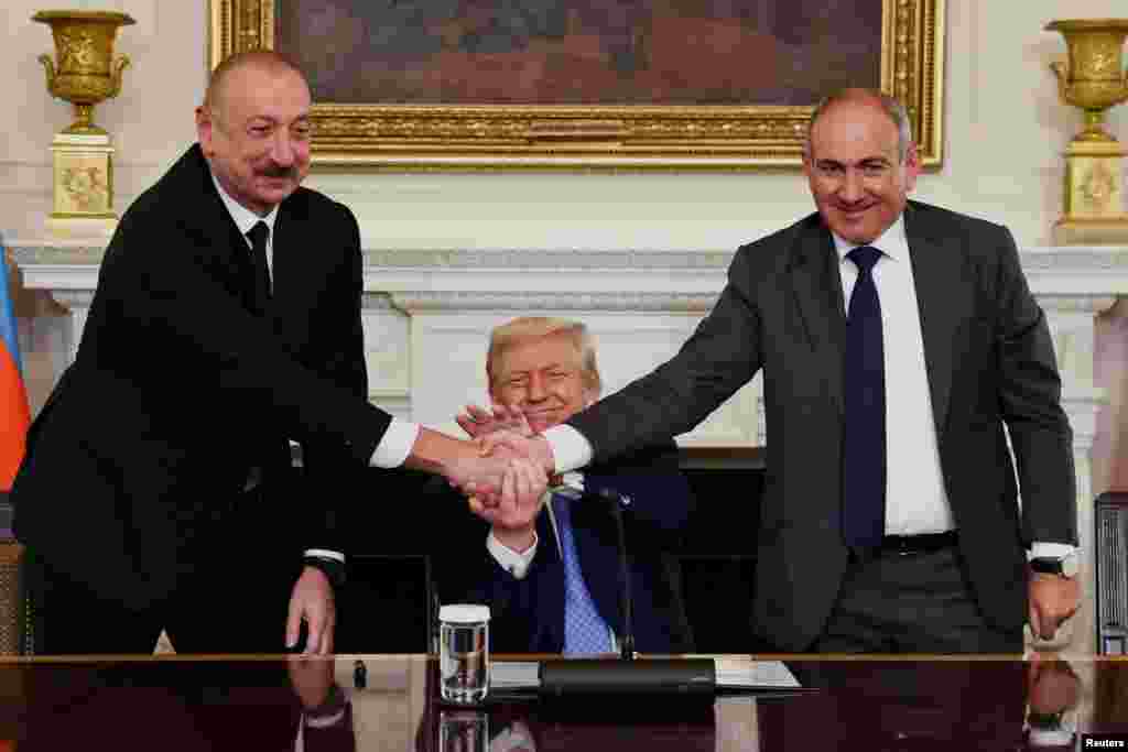 US President Donald Trump (center) holds the hands of Azerbaijani President Ilham Aliyev and Armenian Prime Minister Nikol Pashinyan as they attend a trilateral signing event at the White House in Washington, D.C., on August 8.