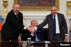 Глава Армении Никол Пашинян и президент Азербайджана Ильхам Алиев на церемонии с президентом США Дональдом Трампом подписали договор о транспортном коридоре между Азербайджаном и входящей в его состав Нахичеванской автономной республикой, 8 августа 2025 года. Фото Reuters