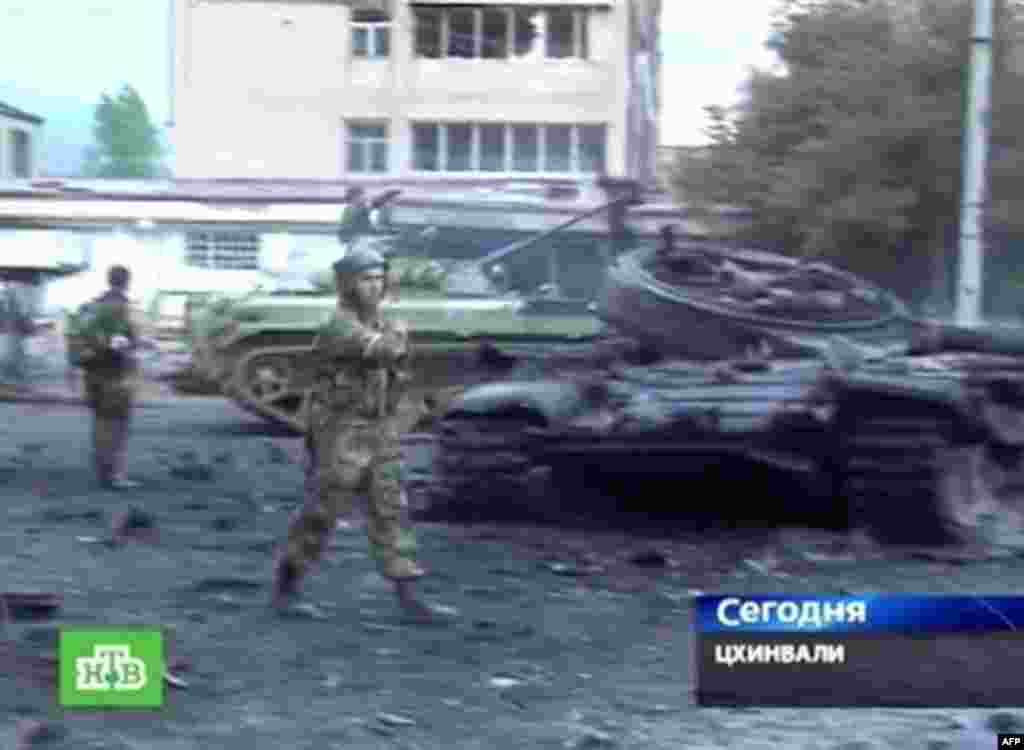 A Russian NTV channel television grab shows South Ossetian separatist troops near a destroyed Georgian tank in Tskhinvali on August 9, 2008. Georgian President Mikheil Saakashvili declared a "state of war" on Saturday as his troops battled it out with Russian forces over the breakaway province of South Ossetia.