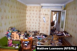 Possessions left strewn inside the living room of an abandoned apartment in Komsomolsky that is still connected to the central heating system.