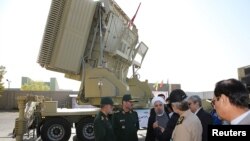 Iranian President Hassan Rohani (3rd L) and Iranian Defense Minister Hossein Dehghan (2nd L) stand in front of the new air defense missile system Bavar-373, in Tehran, August 21, 2016