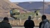 A Tunisian soldier and refugees watch as a Chinook helicopter lands at a border crossing station in western Libya.