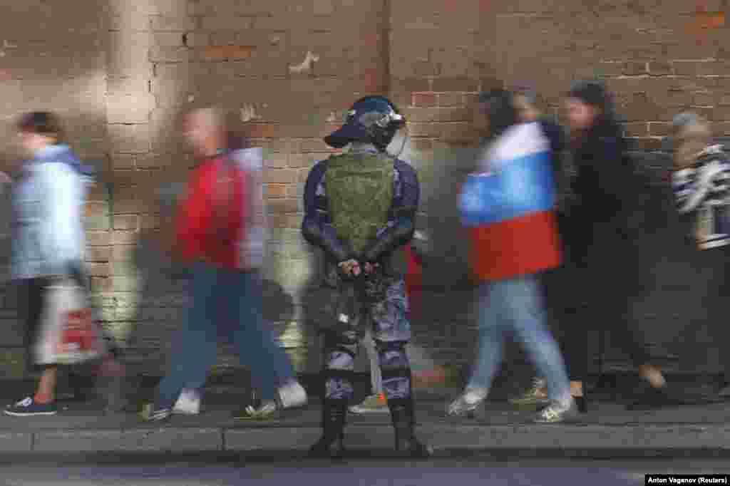 Protesters walk past an officer of the Russian National Guard during a rally against pension reforms in St. Petersburg on September 16. (Reuters/Anton Vaganov)