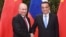 Russian President Vladimir Putin (L) and Chinese Premier Li Keqiang shake hands during a meeting in the Great Hall of the People in Beijing on June 8.