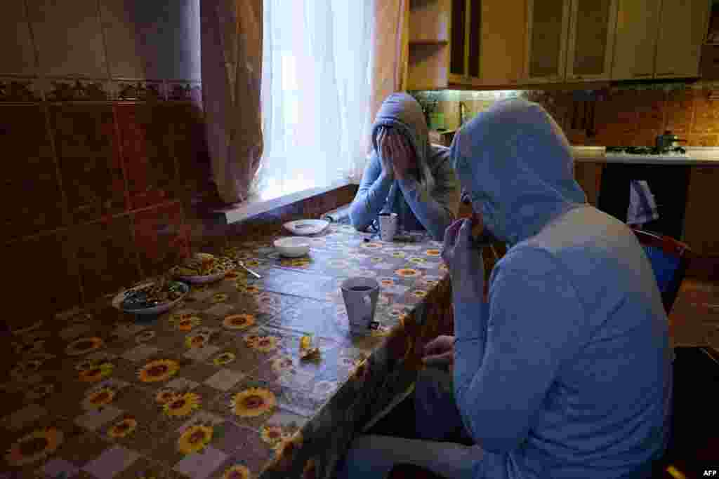 Chechen gay men, who fled persecution in the North Caucasus region, sit around a table in their flat in Moscow. (Naira Davlashyan)