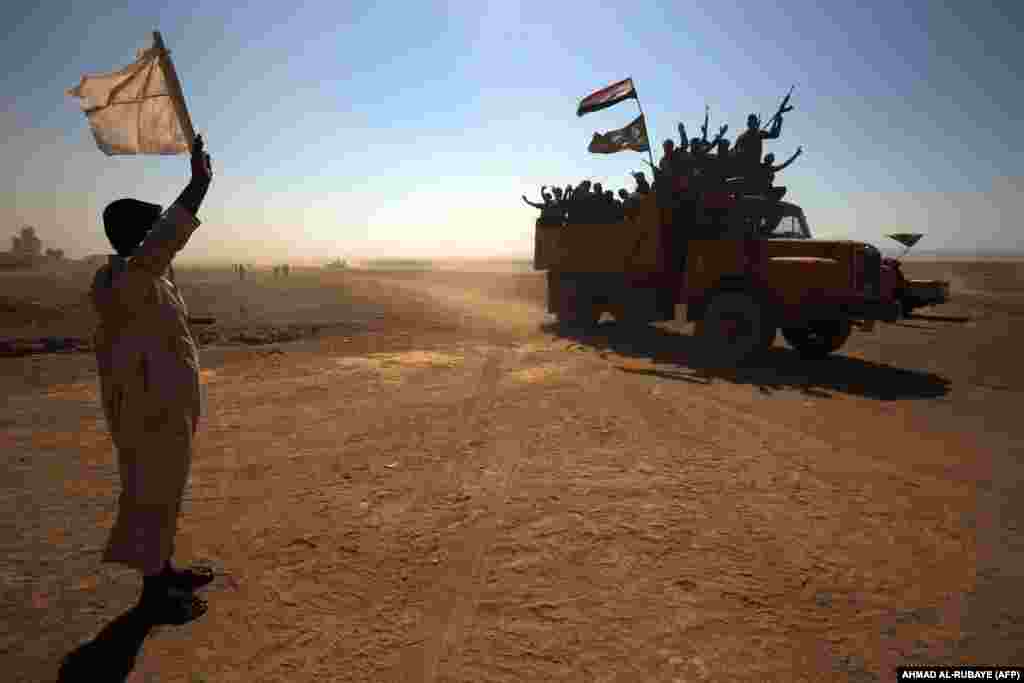 An Iraqi man waves a white flag as Iraqi forces and fighters from the Hashed al-Shaabi (Popular Mobilization units) advance toward the Islamic State extremist group&#39;s stronghold of Hawija on October 1 in their ongoing battle to recapture the town from the militants. (AFP/Ahmad al-Rubaye)