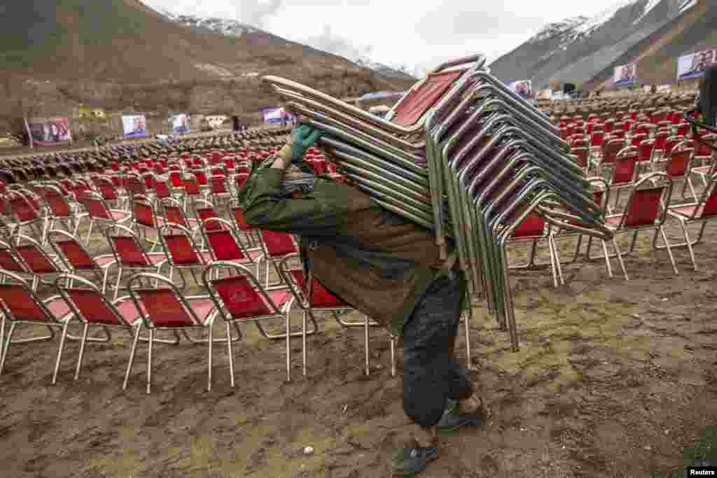 A supporter of presidential candidate Zalmai Rasul carries chairs as he prepares for an election rally in Panshir, northern Afghanistan. (Reuters/Zohra Bensemra)