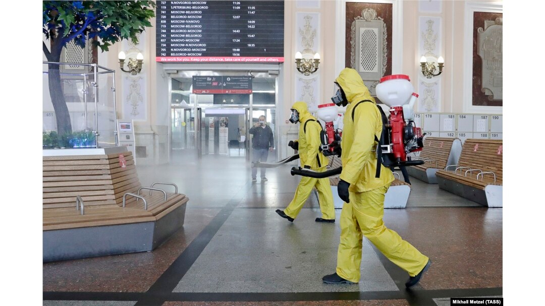 Russian government workers disinfect a Moscow train station as authorities step up efforts to curb a new surge in coronavirus cases.