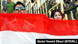 Fans of Iraq's national soccer team hold up the Iraqi flag in Irbil, the capital of the autonomous Kurdish region.