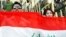 Fans of Iraq's national soccer team hold up the Iraqi flag in Irbil, the capital of the autonomous Kurdish region.