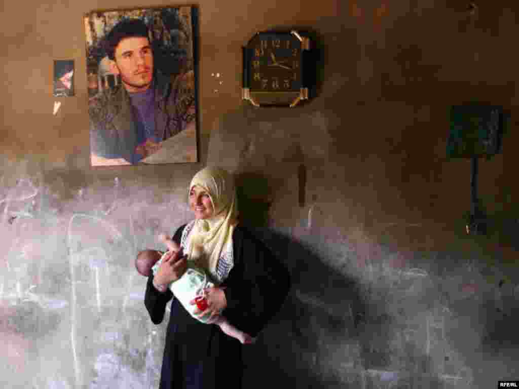 Lebanon, A mother and her baby with the picture of her husband who is a hizbullah supporter in Lebanon, undated