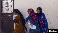 Жени напускат в дома си в турския пограничен град Акакале, ударен от ракета, изстреляна от Сирия