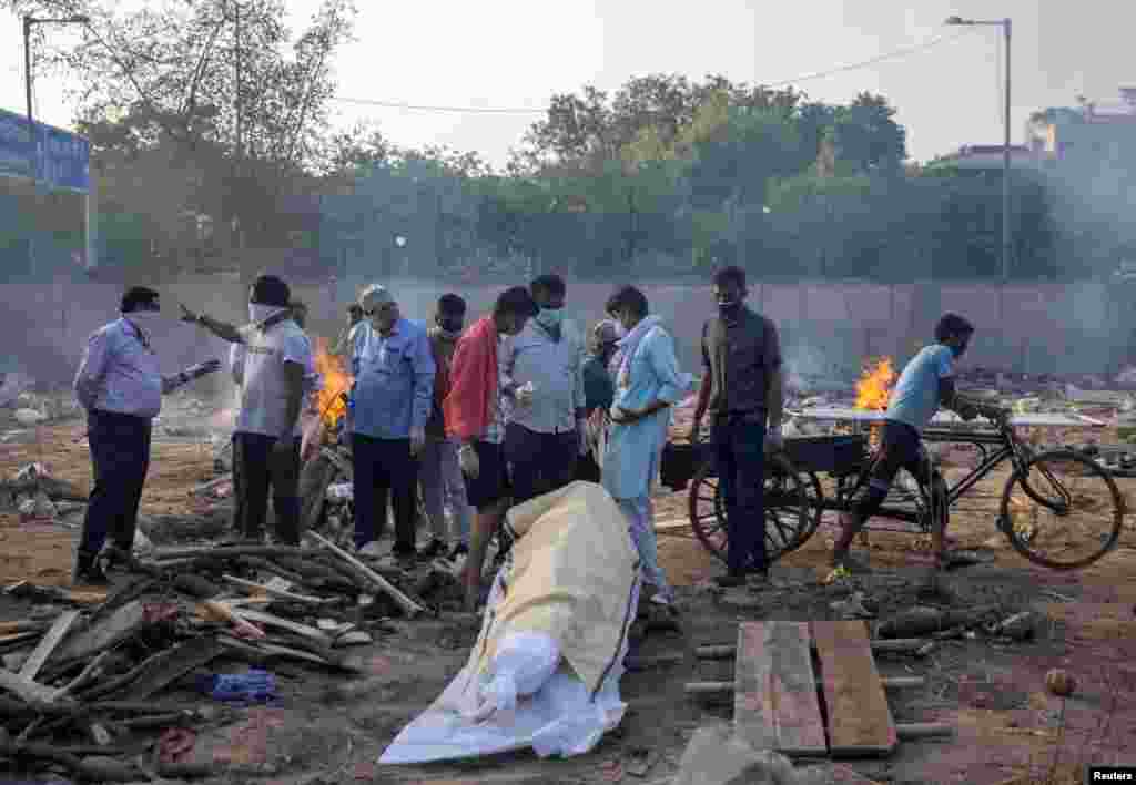 Članovi porodice i rodbina pripremaju se za kremiranje tijela osobe koja je umrla od COVID-a 19 na tlu krematorija u New Delhiju, 22. april.