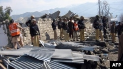 Pakistani police officials inspect the site of a bomb blast in the northwestern Lower Dir district on February 3.