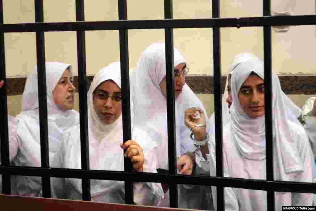 Female Islamist demonstrators stand behind bars during a trial at a court in Alexandria, Egypt, on November 27. The court handed down 11-year sentences to 21 of the demonstrators. Seven defendants are minors and will be sent to a juvenile home, while the remainder were jailed. (EPA/Mahmoud Taha/Almasry Alyoum)