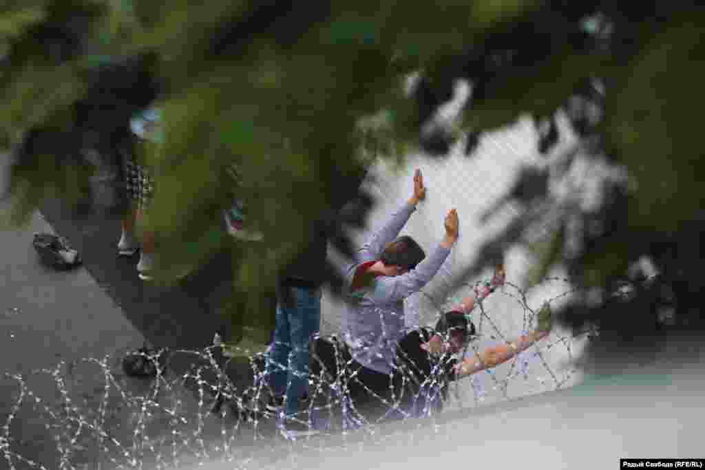 Людзі, якіх затрымалі падчас пратэстаў супраць нерэгістрацыі кандыдатаў, стаяць каля сьцяны ва ўнутраным дворыку Савецкага РУУС. 14 ліпеня 2020 году