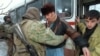 Российский солдат проверяет пассажиров автобуса, выезжающего из Чечни, пытаясь найти оружие на границе с Дагестаном 24 декабря 1994 года