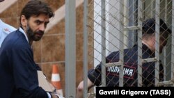 Former Russian minister Mikhail Abyzov (left) is escorted to a court in Moscow on May 23. 