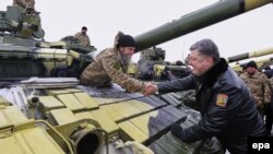 Ukrainian President Petro Poroshenko (right) greets soldiers at a military base in the eastern Ukrainian town of Chuguyev, in the Kharkiv region, on December 6.