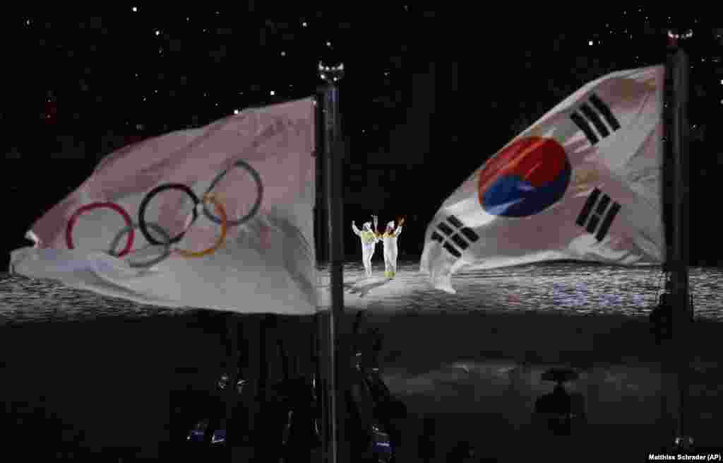 The Olympic torch being carried into the stadium. South Korean figure skater Yuna Kim lit the Olympic cauldron.