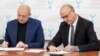 «Ректор» луганського «вишу» Валерій Філіппов (ліворуч) підписує договір із заступником мера міста Рош-ла-Мольєр Дідьє Рішаром