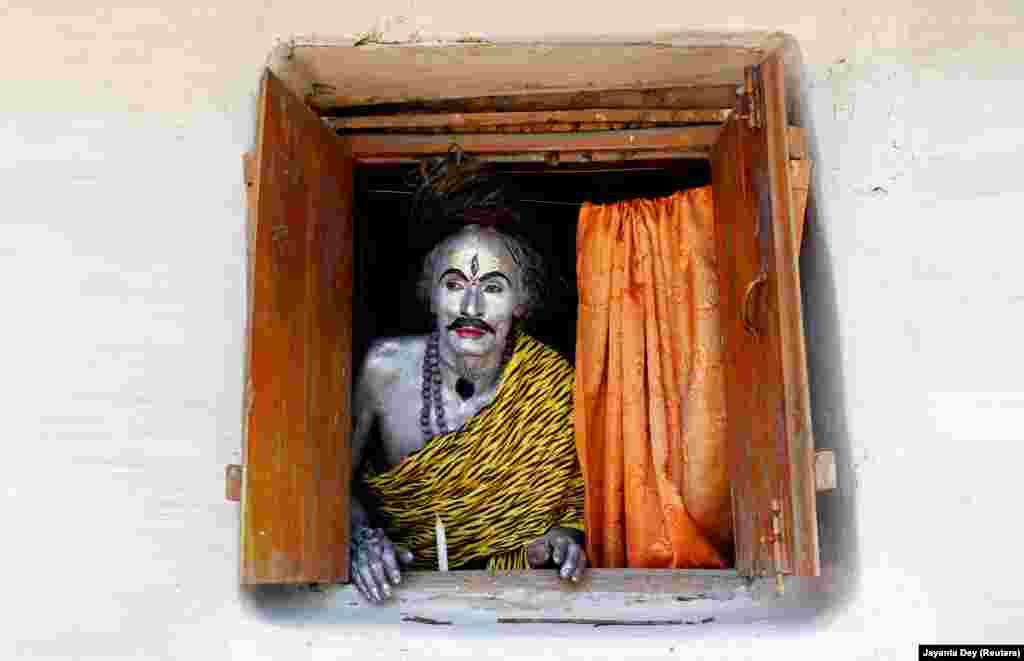 A devotee dressed as the Hindu god Shiva looks out from a window as he waits to perform during the annual Shiva Gajan religious festival on the outskirts of Agartala, India. (Reuters/Jayanta Dey)