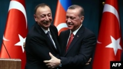 Turkey -- Azerbaijani President Ilham Aliyev (L) and Turkish President Recep Tayyip Erdogan hug after signing bilateral agreements following the 5th Turkey-Azerbaijan High Level Strategic Cooperation Council meeting at the Presidential Complex in Ankara, 