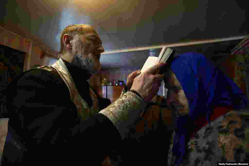 A priest leads a service in a residential house on the eve of Orthodox Epiphany in the village of Lesiny, Belarus, on January 18. (Reuters/Vasily Fedosenko)