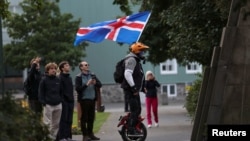 Një burrë me një flamur islandez në një park para një referendumit nëse Islanda duhej të rifillote negociatat e pranimit me Bashkimin Evropian, në Rekjavik, Islandë, më 29 gusht 2026.
