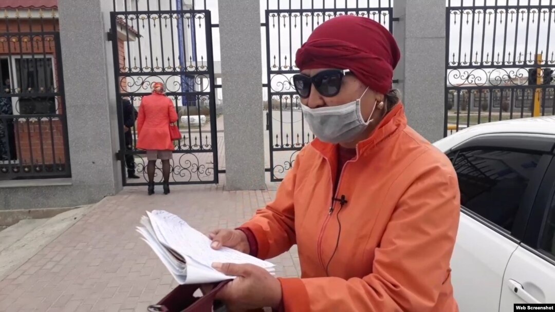 Жительница Кызылорды Акжан Ногаева читает стихи у здания акимата Кызылординской области. Кызылорда, 1 апреля 2020 года.