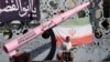 A man walks next to a symbolic mockup of an Iranian missile and an Iranian flag on Imam Hussein Square in Tehran.