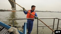 Хукҳои мурдаро аз оби рӯди Ҳуангпу берун мекашанд