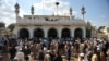 In this file photo, people gather outside a mosque in Nowshera after a bomb exploded there in March 2011.
