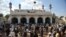 In this file photo, people gather outside a mosque in Nowshera after a bomb exploded there in March 2011.